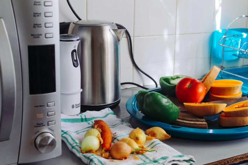 A modern home kitchen counter displaying fresh vegetables and appliances, ideal for healthy cooking.